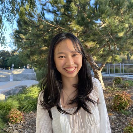 Sydney Quach standing in front of a tree.