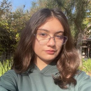 Sarah Rios in a green hoodie in front of a tree