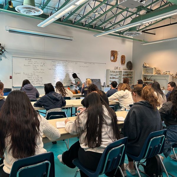 Students listen to a lecture in a classroom setting.