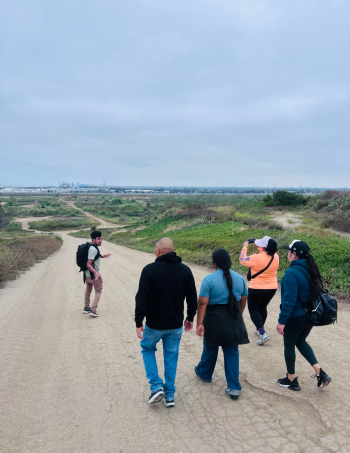 A photograph of a person leading a group of people down a road.