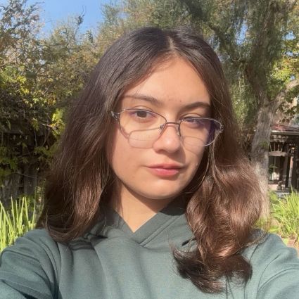 Sarah Rios in a green hoodie in front of a tree
